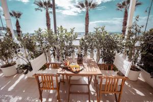 stół i krzesła na patio z palmami w obiekcie Break for two w Agropoli