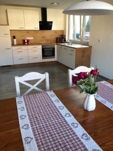 a kitchen with a table with a vase of flowers on it at AlbTraum in Reutti