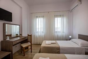 1 Schlafzimmer mit 2 Betten, einem Schreibtisch und einem Spiegel in der Unterkunft Airport House in Otopeni