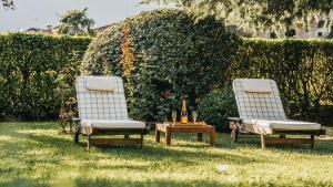 two chairs and a table with wine bottles on the grass at Villa Dervio in Dervio