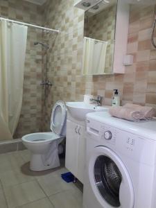 een badkamer met een wasmachine en een toilet bij Ristevski Apartment in Bitola
