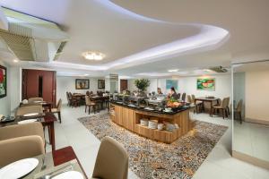 een lobby met een restaurant met tafels en stoelen bij Diamond Legend Hotel in Hanoi