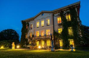 a large white building with lights on at night at Chateau de Bézyl in Sixt-sur-Aff