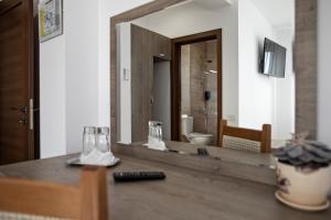 a bathroom with a large mirror and a remote control at Airport House in Otopeni