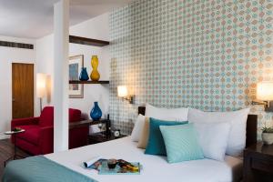 Prima Royale Hotel في القدس: غرفة نوم بسرير وكرسي احمر