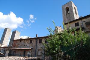 an old building with a tower and a church at Orto di Emma in San Gimignano