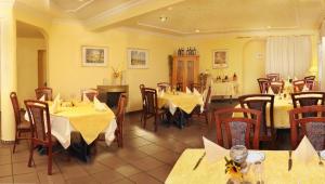 a restaurant with tables and chairs in a room at Hotel Landhaus in Eschweiler