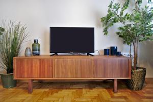 TV en un centro de entretenimiento de madera con 2 plantas en Photographers House en Atenas