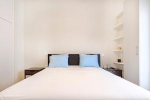 une chambre avec un grand lit blanc avec des oreillers bleus dans l'établissement Photographers House, à Athènes