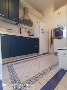 摩德納的住宿－casa dolce casa，厨房配有蓝色橱柜和白色冰箱