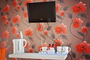 a tv on top of a shelf with cups and mugs at Tobermory Hotel in Blackpool