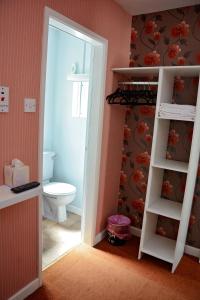 a bathroom with a toilet and a door leading into a room at Tobermory Hotel in Blackpool