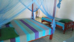 sypialnia z 2 łóżkami i niebieskimi zasłonami w obiekcie Lagoon Inn w mieście Hambantota