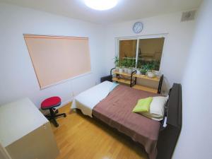 a bedroom with a bed and a large window at Minpaku Mon in Sapporo