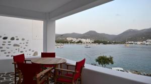 a balcony with a table and chairs overlooking the water at Nicolas House in Rakhídhion