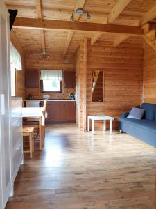 a kitchen and living room in a log cabin at Domki letniskowe Sawinda in Rewal