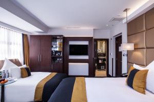 a hotel room with two beds and a television at Montcalm Piccadilly Townhouse, London West End in London