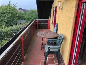 un patio con 2 sillas y una mesa en el balcón en Natürlicher Holzkomfort im hessischen Kegelspiel, en Hünfeld