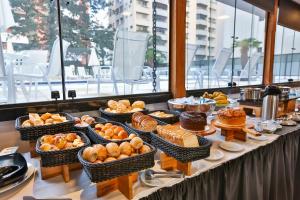 a buffet with many different types of bread and pastries at Roomo Transamerica SP Itaim Bibi in Sao Paulo