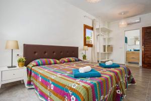 a bedroom with a large bed with blue pillows at Villa Corito in Playa Blanca