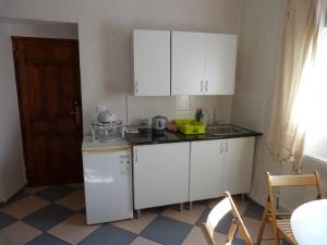 a small kitchen with white cabinets and a sink at Mi Casa in Oria