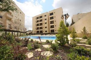 a swimming pool in the middle of a building at Dair Ghbar Apartment in Amman