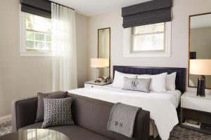 a bedroom with a large white bed and a chair at The Whitney Hotel Boston in Boston