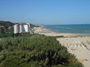 a beach with a bunch of chairs and people on it at Mini Appartamento Lido Riccio in Ortona