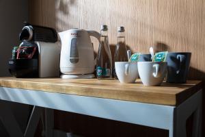 a counter with a toaster and cups and bottles on it at Anchor House Sopot in Sopot