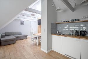 a kitchen and living room with a couch and a table at Anchor House Sopot in Sopot