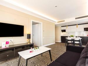 ein Wohnzimmer mit einem Sofa und einem Flachbild-TV in der Unterkunft VacationClub – Baltic Park Fort Apartament E.202 in Świnoujście
