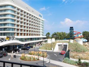 duży budynek z parkingiem przed nim w obiekcie VacationClub – Baltic Park Fort Apartament E.202 w Świnoujściu