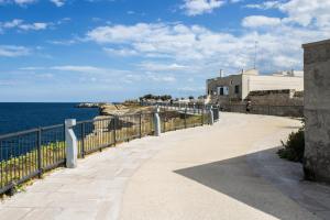 a walkway next to the ocean with a building at Casa Nori in Polignano a Mare