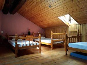 two beds in a room with a wooden ceiling at Refugi Rural Vall de Siarb in Llagunes