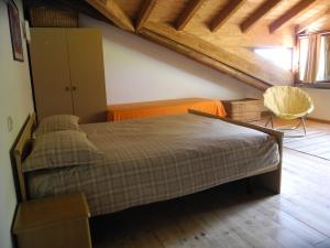sypialnia z dużym łóżkiem na poddaszu w obiekcie Agriturismo Piccolo paradiso w mieście Pianello Del Lario