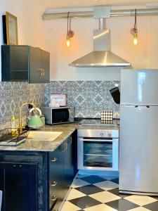 a kitchen with blue cabinets and a white refrigerator at Shantell Luxury Apartment in Netanya