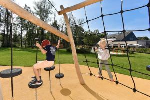 two young children playing on a playground at Novotel Wavre Brussels East in Wavre