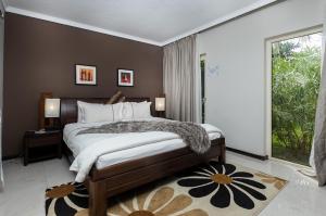 a bedroom with a bed and a large window at Red Mango Hotel and Apartments in Sekondi-Takoradi