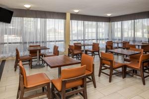 a dining room with tables and chairs and windows at Days Inn by Wyndham Wilson in Wilson