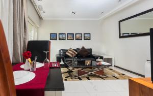 ein Wohnzimmer mit einem schwarzen Stuhl und einem Tisch in der Unterkunft Red Mango Hotel and Apartments in Takoradi