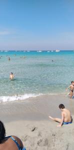 a group of people in the water at the beach at Villa Maria in Isola delle Femmine
