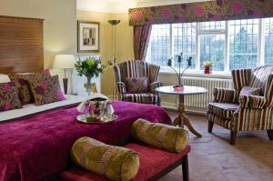 a hotel room with a bed, table and chairs at Macdonald Craxton Wood Hotel & Spa in Ledsham