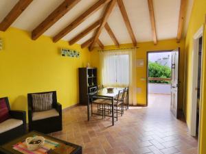 a living room with yellow walls and a table and chairs at Arriba y Abajo Cadiz in Zahora