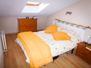 1 dormitorio con 1 cama con almohadas de color naranja en Apartamentos Formigal - admite mascotas, en Formigal