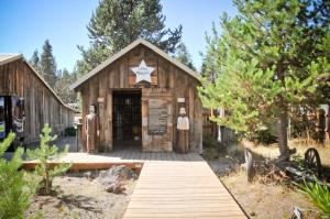 ein Holzgebäude mit einem Schild davor in der Unterkunft Bend-Sunriver Camping Resort Cottage 1 in Sunriver
