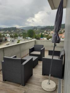 a patio with chairs and an umbrella on a roof at Basto Vila Hotel in Cabeceiras de Basto