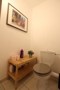 La salle de bains est pourvue de toilettes et d'une table en bois. dans l'établissement Colmar City Center - Cosy Appartement BED' N' BREDALA Max, à Colmar
