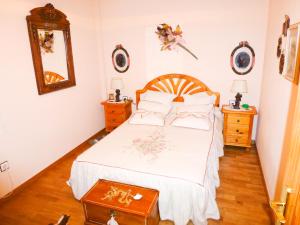 フォルミガルにあるApartamentos Formigal - admite mascotasのベッドルーム1室(ベッド1台、ナイトスタンド2台、鏡付)