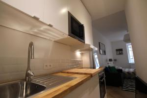 cocina con fregadero y TV en la pared en Colmar City Center - Quiet Studio ALSACE, en Colmar