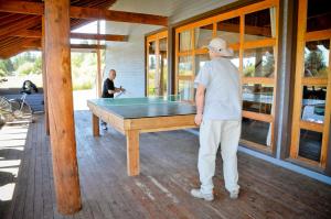 a man standing in front of a pool table at Bend-Sunriver Camping Resort Studio Cabin 8 in Sunriver